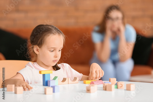 Little girl with autistic disorder playing with blocks at home