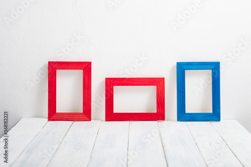 empty red and blue picture frames on white wooden table