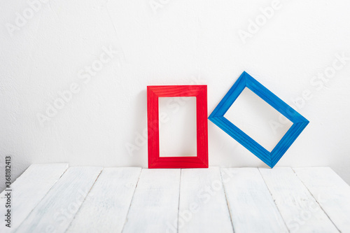 empty red and blue picture frames on white wooden table © tstock