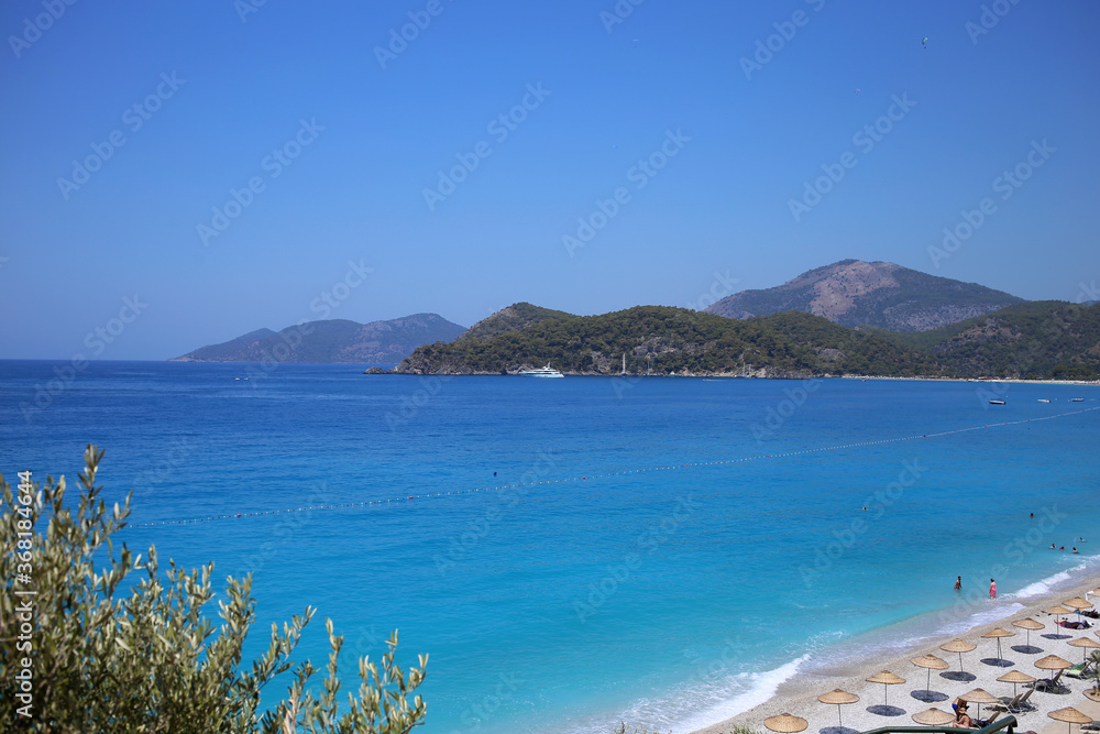 A beautiful view of the mountainous coast of the blue Mediterranean Sea, in the resort town of Oludeniz in Turkey.