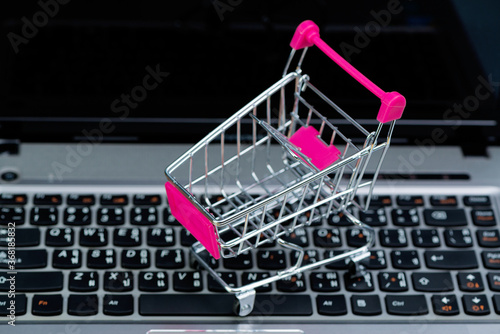 Shopping cart or supermarket trolley with laptop notebook, e-commerce and online shopping concept.