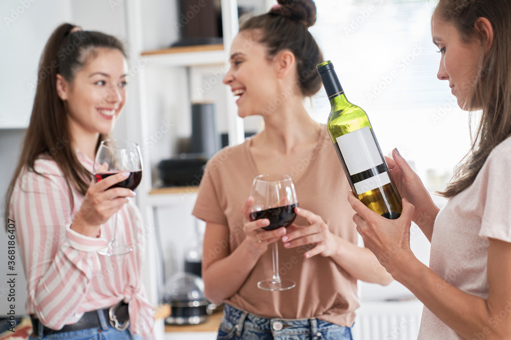 Three women drinking red wine at home