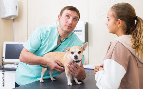 Upset girl with dog consulting by veterinarian. High quality photo