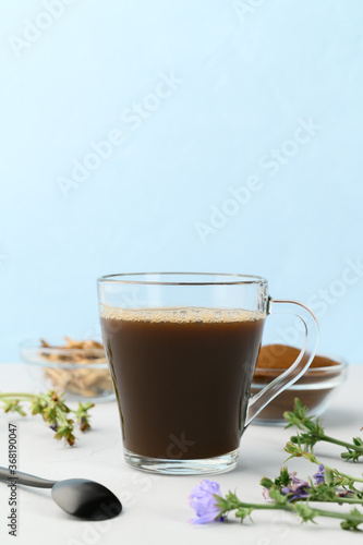 Alternative to coffee. Healthy drink chicory. Chicory coffee in a glass cup on a light gray table. Copy space, vertical orientation.