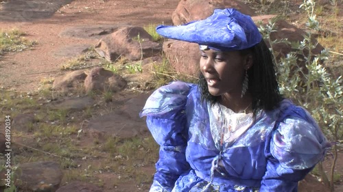 herero woman wearing a Victorian style dress outdoors in a village in north Botswana photo