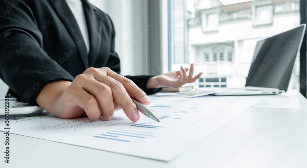 The hands of a male businesswoman are analyzing and calculating the annual income and expenses in a financial graph that shows results To summarize balances overall in office The hands of a male businesswoman are analyzing and calculating the annual income and expenses in a financial graph that shows results To summarize balances overall in office