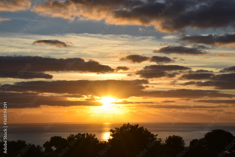 Beautiful sunset landscape above the sea, orange sky with sun shining  and clouds