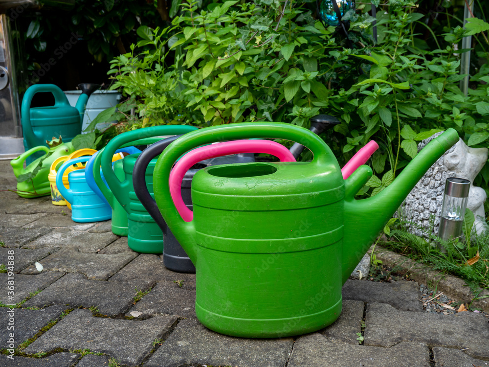 colorful watering can in garden colorful watering can in garden