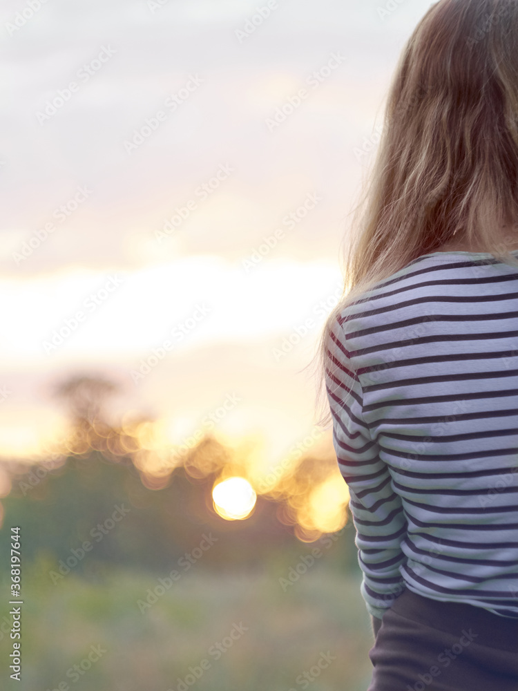 Girl in a striped sweater at sunset