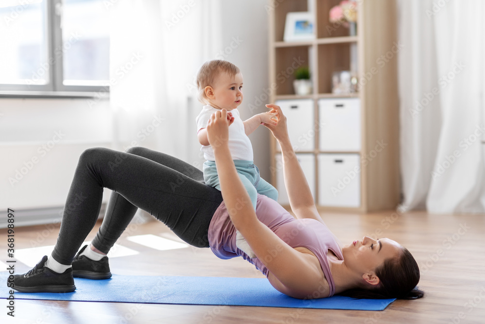 Obraz premium family, sport and motherhood concept - mother with little baby exercising at home