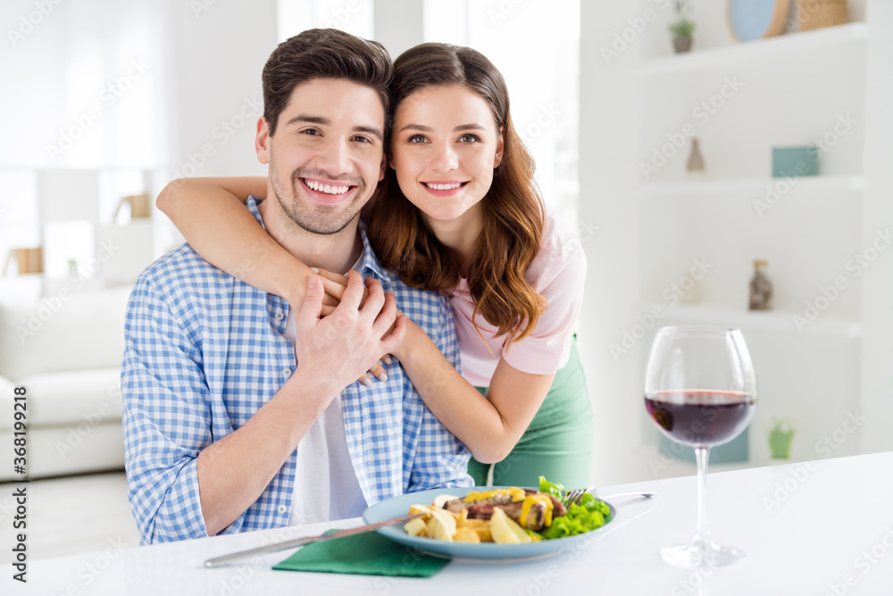 Portrait of two nice attractive careful cheerful cheery spouses guy eating tasty yummy dish meal enjoying staying home leisure domestic restaurant in light white interior kitchen house apartment