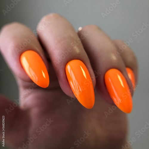 Stylish trendy orange female manicure.Hands of a woman with orange manicure on nails