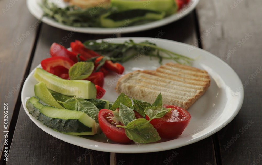 Healthy organic vegetable breakfast, tomato toast salad basil cucumber arugula