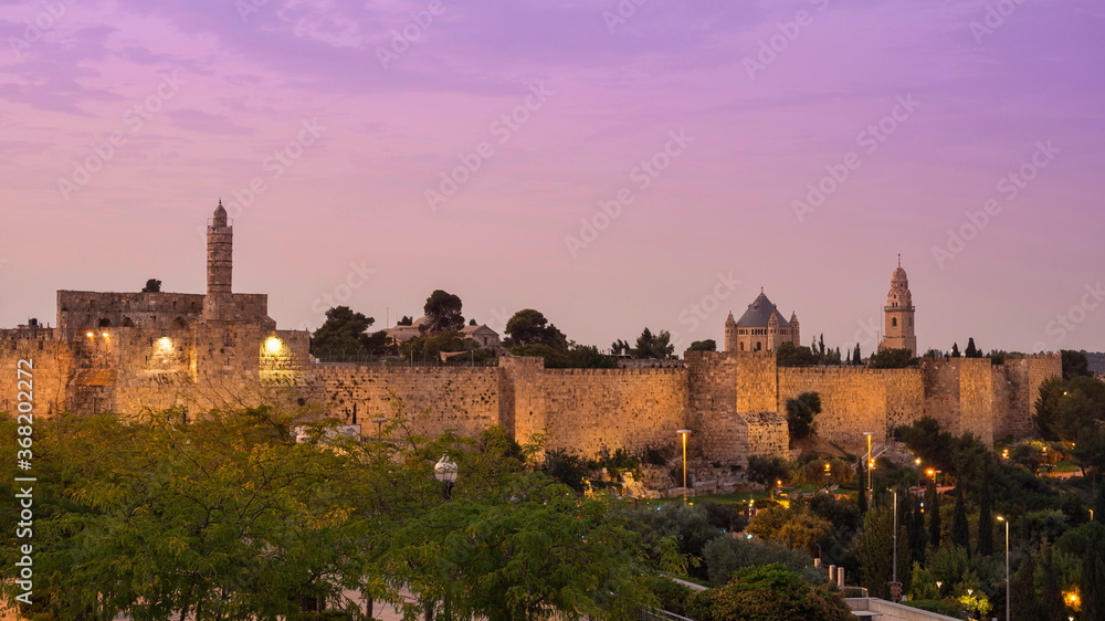 Sunrise view of the Old City wall of Jerusalem, from the mamluk minaret of the Jerusalem Citadel to the Dormition Abbey on Mount Zion, with its lead-covered basilica and a bell tower