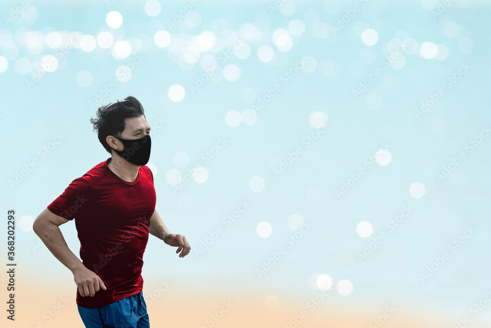 Asian man running and exercise with wearing a protective mask COVID-19 an outdoor workout on the beach.