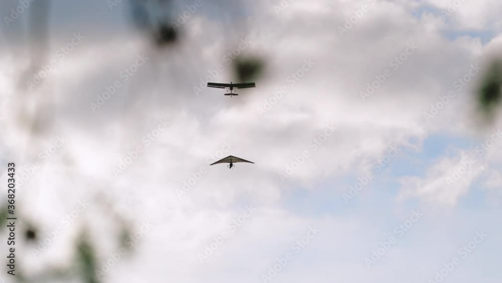 Airplane tows Hang Glider gaining altitude in clouds, tandem hang gliding Airplane tows Hang Glider gaining altitude in clouds, tandem hang gliding
