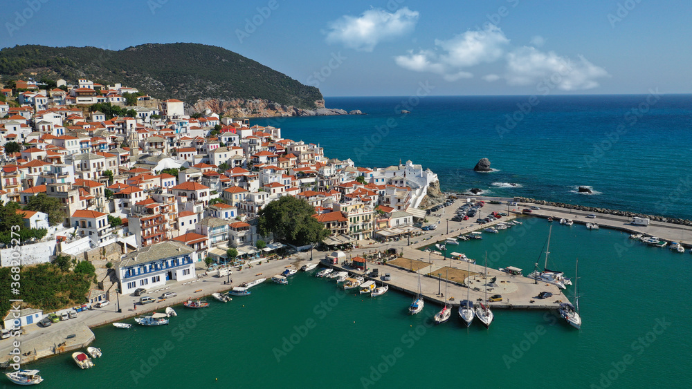 Aerial drone photo of beautiful main town and port of Skopelos island featuring landmark church of Virgin Mary and uphill venetian castle, Sporades islands, Greece
