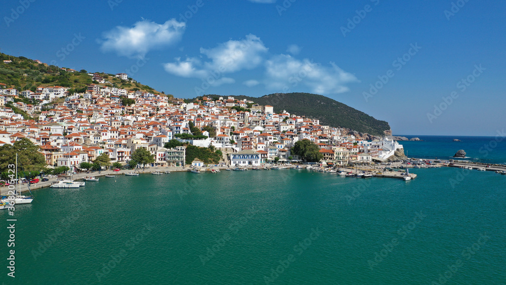 Aerial drone photo of beautiful main town and port of Skopelos island featuring landmark church of Virgin Mary and uphill venetian castle, Sporades islands, Greece
