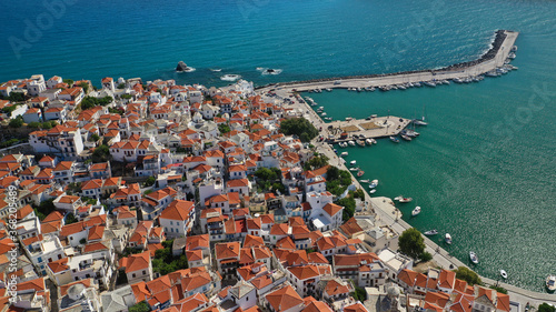 Aerial drone photo of beautiful main town and port of Skopelos island featuring landmark church of Virgin Mary and uphill venetian castle, Sporades islands, Greece