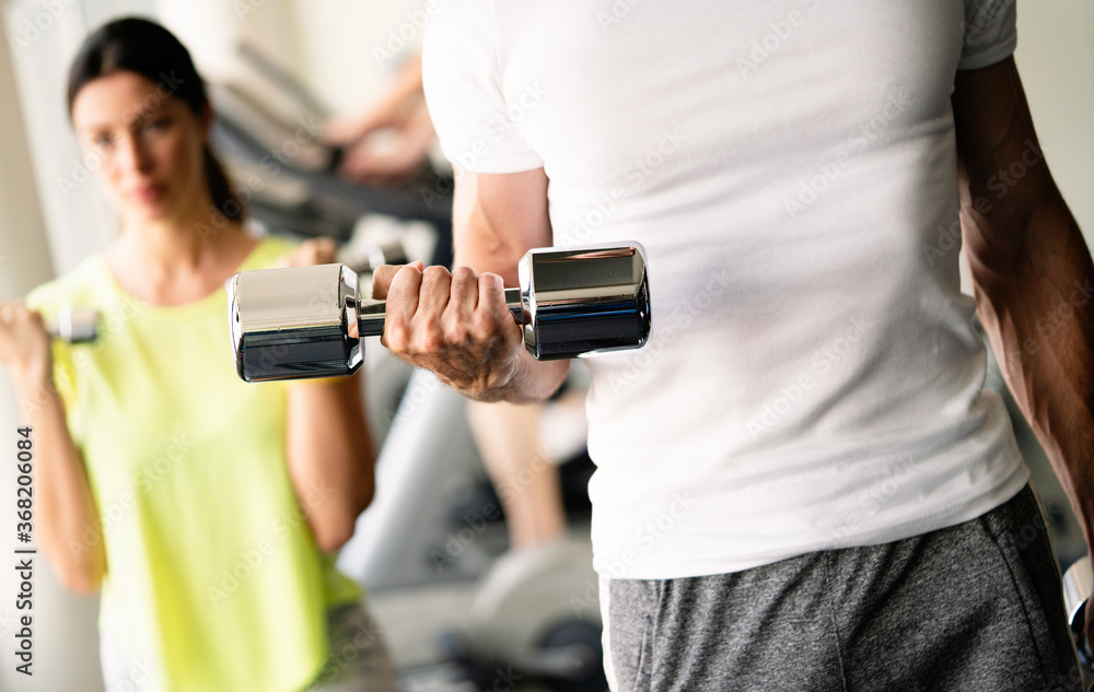 Sport, fitness, lifestyle and people concept. Group of happy poeple with dumbbells in gym Sport, fitness, lifestyle and people concept. Group of happy poeple with dumbbells in gym