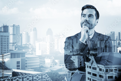 Canvas Print Young handsome businessman in suit with hand on chin thinking how to succeed, new career opportunities, MBA