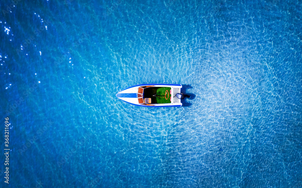 Top view of a white boat in the blue sea. Top view of a white boat in the blue sea.
