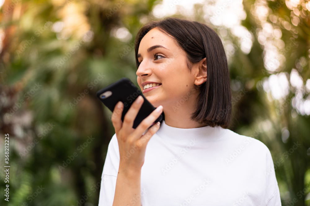 Young caucasian woman using a phone at outdoors Young caucasian woman using a phone at outdoors