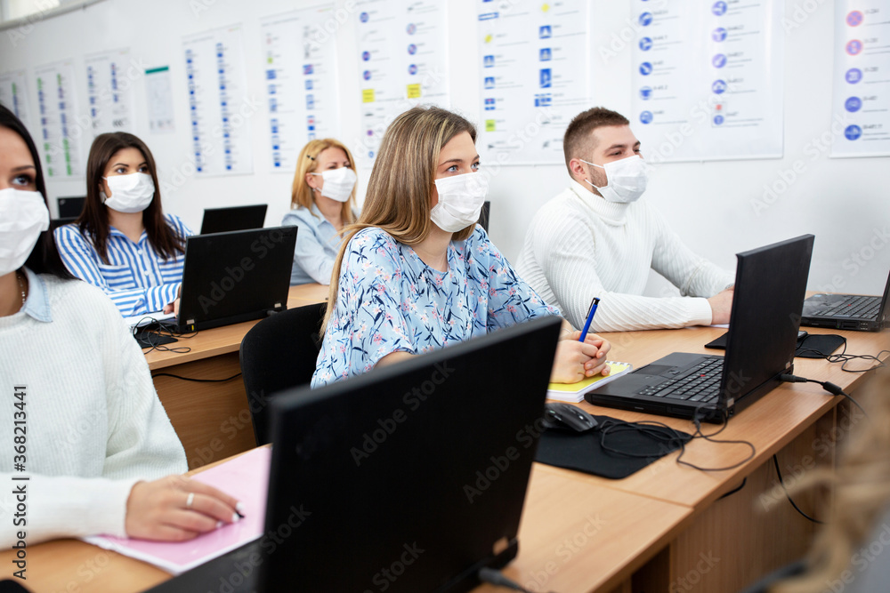 Students with safety and protection masks sitting in the classroom Students with safety and protection masks sitting in the classroom
