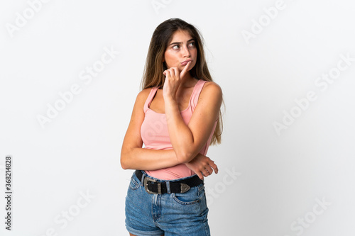 Young caucasian woman isolated on white background having doubts while looking up