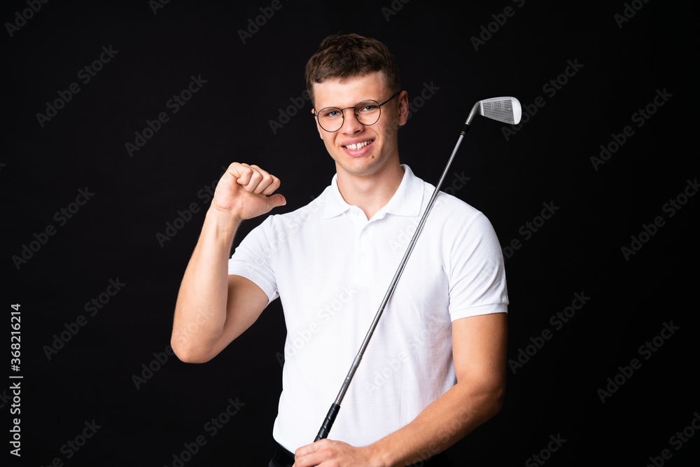 Handsome young golfer player man over isolated black background Handsome young golfer player man over isolated black background