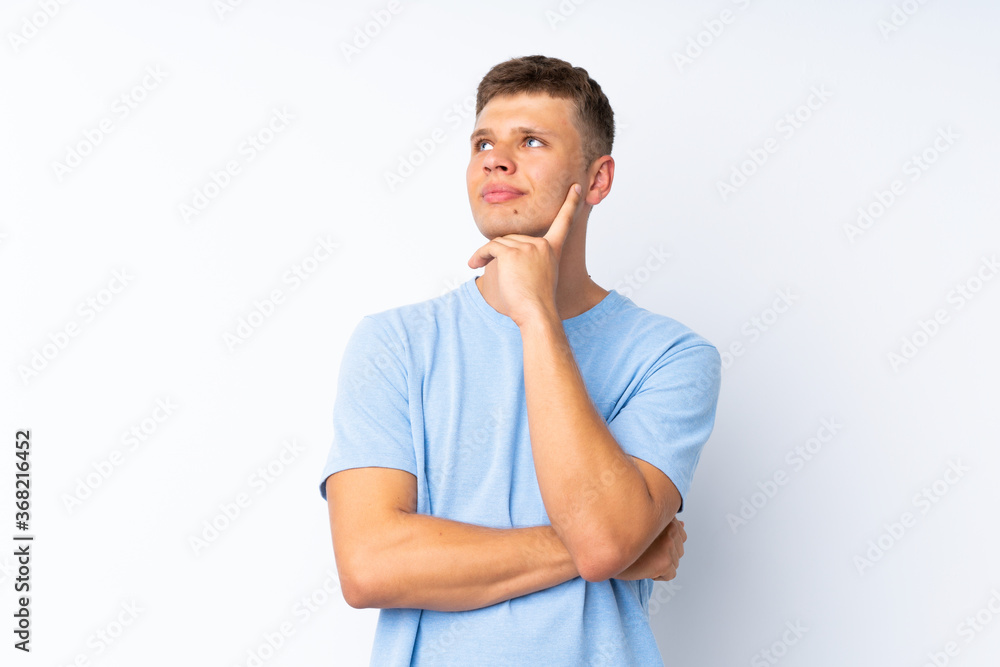 Young handsome man over isolated white background thinking an idea while looking up Young handsome man over isolated white background thinking an idea while looking up