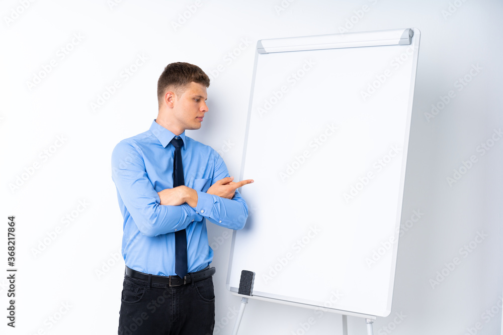 Young businessman giving a presentation on white board giving a presentation on white board and pointing it Young businessman giving a presentation on white board giving a presentation on white board and pointing it