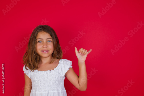 Little caucasian girl with blue eyes wearing white dress standing over isolated red background showing up number six Liu with fingers gesture in sign Chinese language © Roquillo