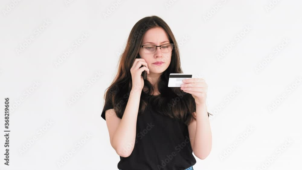 Bank fraud. Phone scam. Confused woman telling personal credit card information isolated on white. Bank fraud. Phone scam. Confused woman telling personal credit card information isolated on white.