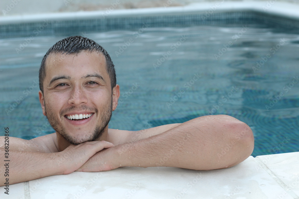 Handsome ethnic man smiling in swimming pool 