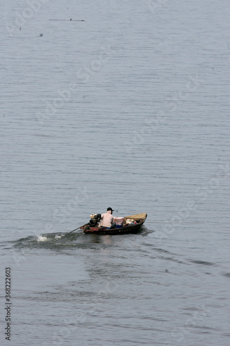 A food merchant goes around by boat in the Jatiluhur Reservoir, Purwakarta, West Java, Indonesia