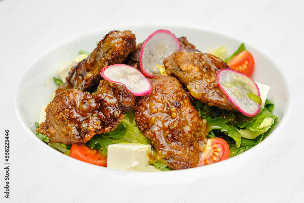 Grilled beef in a sauce with Dejon mustard and soft cheese in a case plate on a gray background. Grilled beef in a sauce with Dejon mustard and soft cheese in a case plate on a gray background.