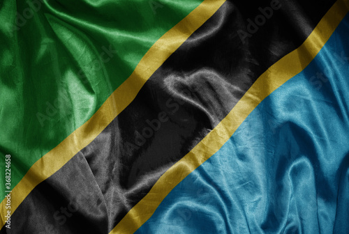 colorful shining big national flag of tanzania on a silky texture