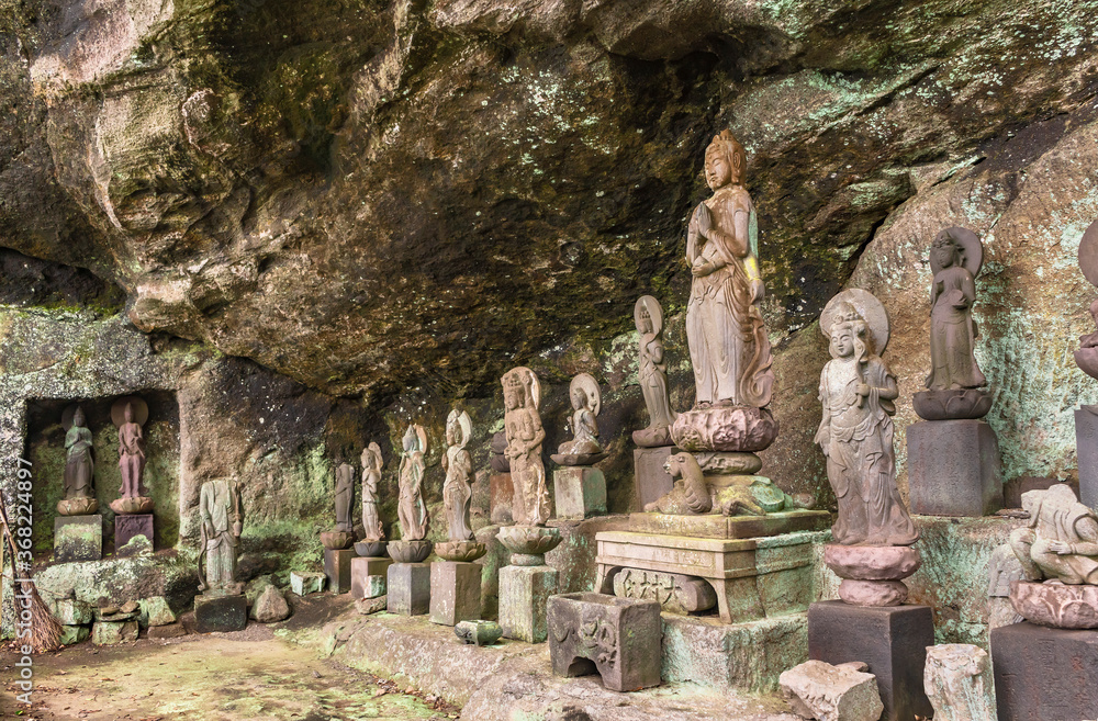 Buddhist statues of deities and monks surrounding the sculpture of Saigoku Kannon bodhisattva created in 18th century by Jingoro Eirei Ono in the Mount Nokogiri.