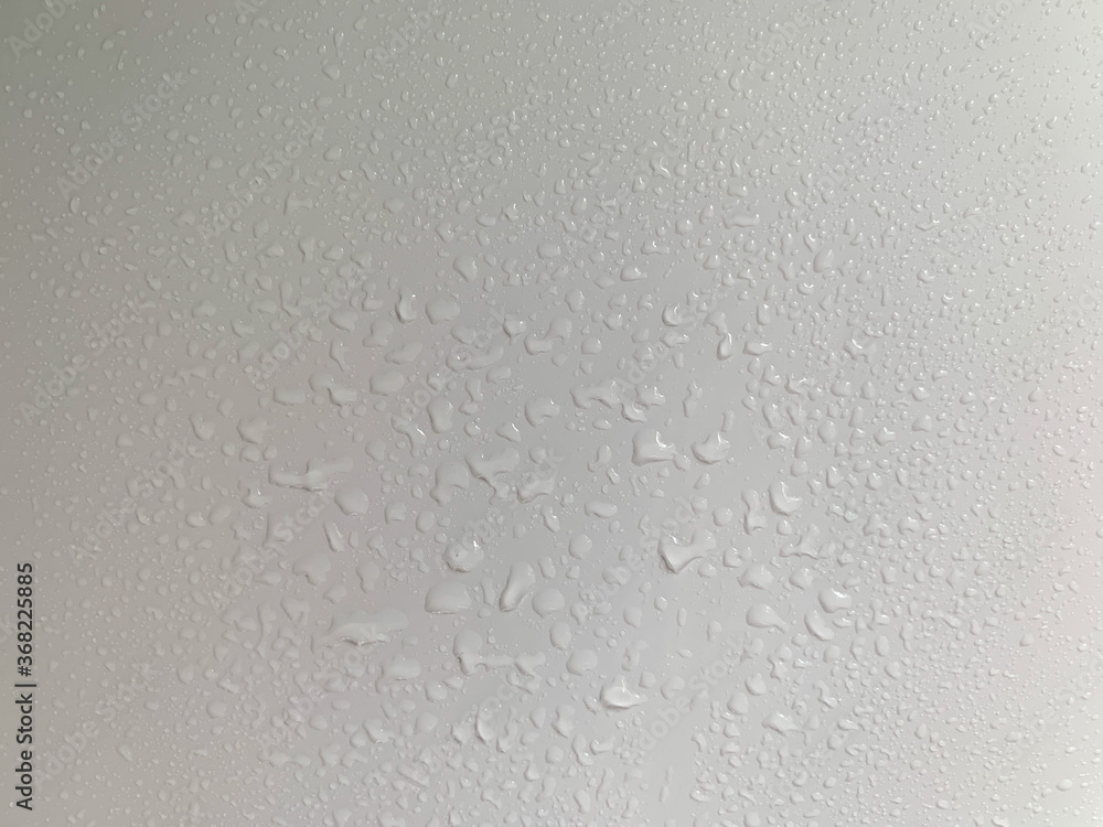 Water droplets formed by condensation on a white surface. The white wall after the rain condensing wall. a drop of water against a white wall. Water droplets formed by condensation on a white surface. The white wall after the rain condensing wall. a drop of water against a white wall.