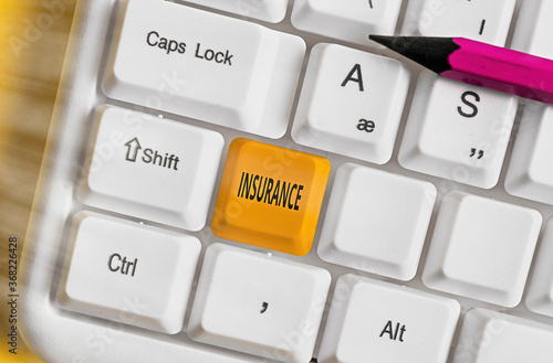 Handwriting text writing Insurance. Conceptual photo coverage by contract whereby one party undertakes to guarantee Different colored keyboard key with accessories arranged on empty copy space photo
