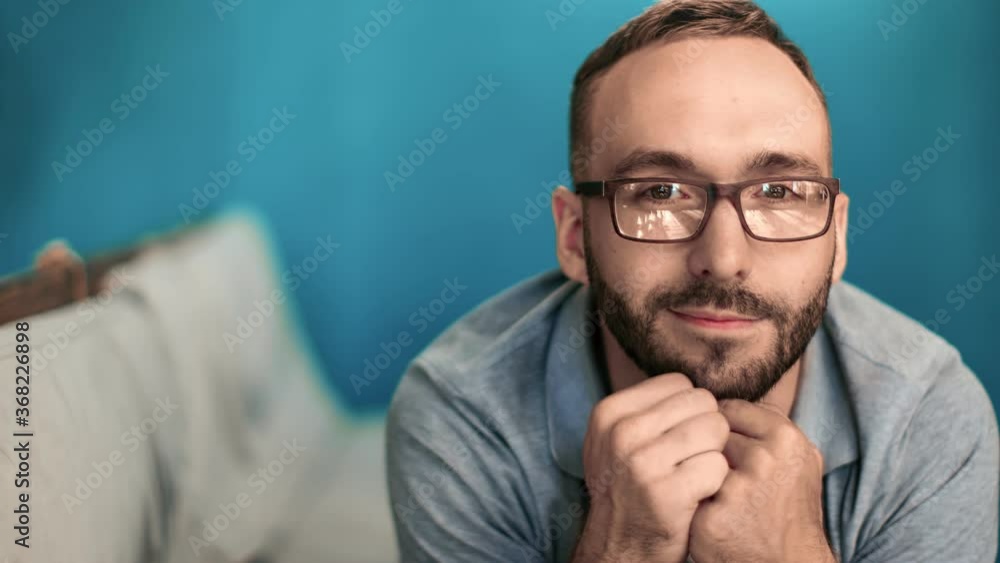 Portrait of bearded guy in glasses lying on couch. Medium close up shot on 4k RED camera Portrait of bearded guy in glasses lying on couch. Medium close up shot on 4k RED camera