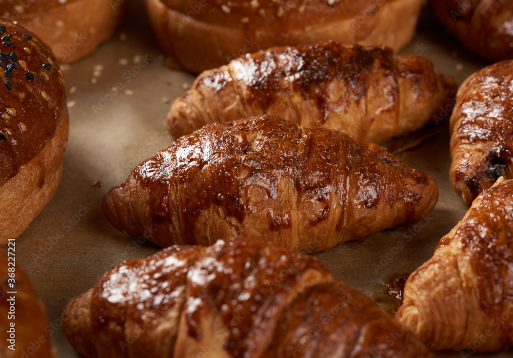 baked croissants in a baking sheet on brown parchment paper baked croissants in a baking sheet on brown parchment paper