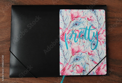 Diary and black folder on the background of a wooden table