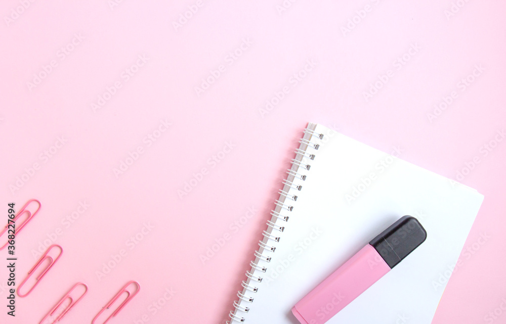 White notepad, pink marker and paper clips on pink background with space for text. School stationery and supplies. Back to school, creative workspace. Minimalistic set of colorful stationery White notepad, pink marker and paper clips on pink background with space for text. School stationery and supplies. Back to school, creative workspace. Minimalistic set of colorful stationery