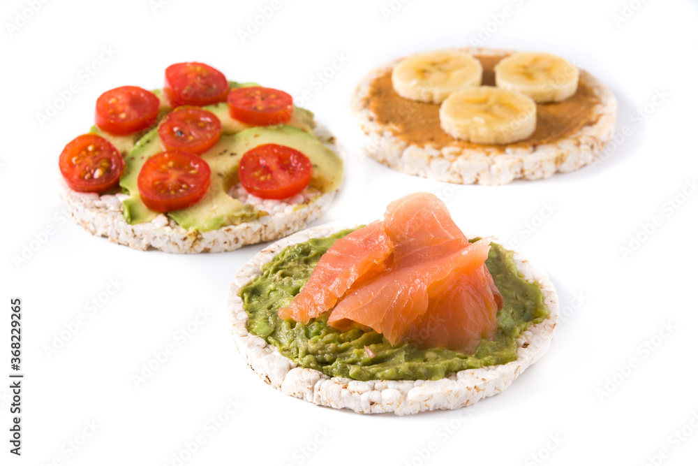 Assortment of ingredients on puffed rice cakes isolated on white background Assortment of ingredients on puffed rice cakes isolated on white background