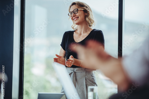 Businesswoman clapping hands in boardroom