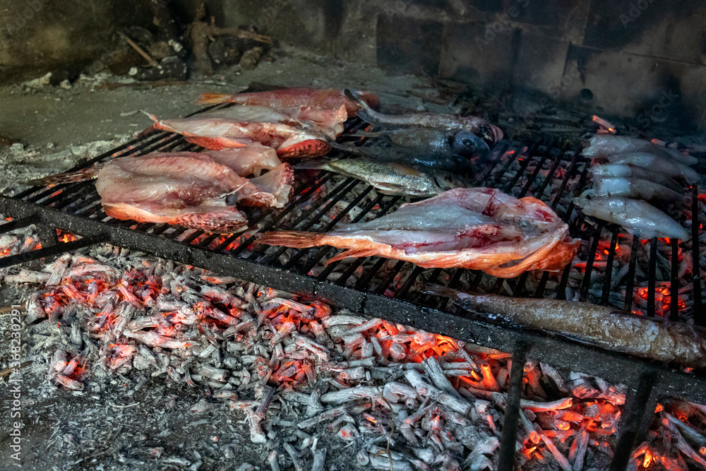 Fresh sea fish on metal grill roasted on ember, ready to eat, mediterranean Croatia