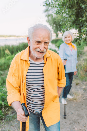 Selective focus of smiling senior man with walking stick looking at camera near wife in park © LIGHTFIELD STUDIOS