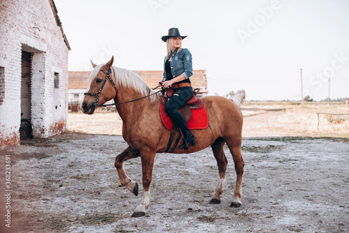 Beautiful girl riding a horse in countryside. © VlaDee
